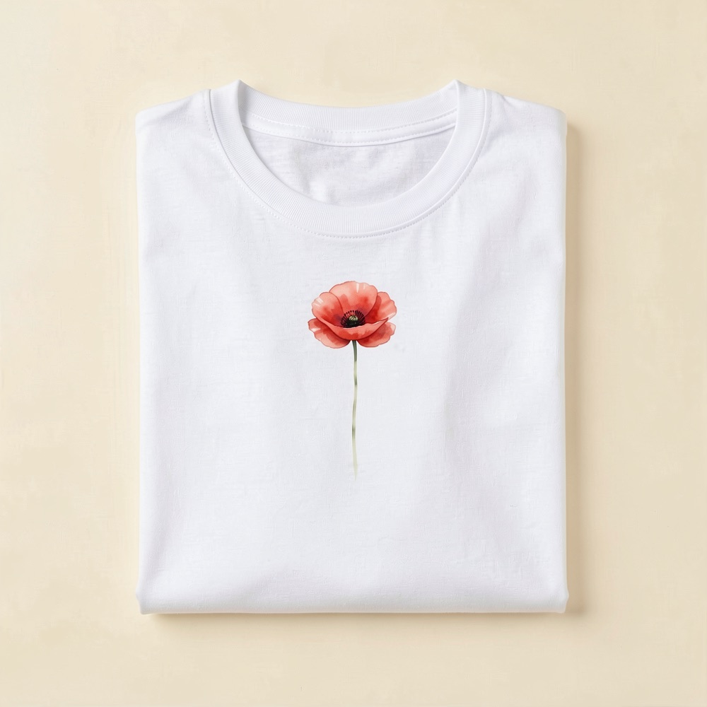 Folded natural-white t-shirt with a watercolour red poppy printed on the chest